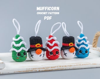 May include: Five crocheted Christmas ornaments, including a snowman, a Christmas tree, and three candy canes. The ornaments are all white with different colored accents. The ornaments are hanging from a white wooden tray. The text "MUFFICORN CROCHET PATTERN PDF" is at the top of the image.