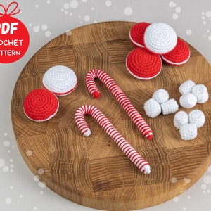 Puede incluir: Una colecci&oacute;n de adornos navide&ntilde;os de ganchillo, que incluyen bastones de caramelo rojos y blancos, adornos redondos y grupos de adornos blancos. La imagen incluye el texto "PDF CROCHET PATTERN" en un c&iacute;rculo rojo.