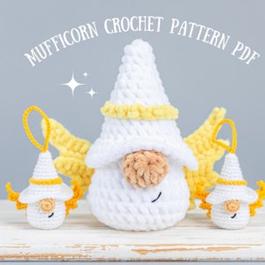 Puede incluir: Un gnomo de crochet blanco con alas amarillas y un sombrero amarillo. Dos gnomos de crochet blancos más pequeños con alas amarillas y sombreros están a cada lado del gnomo más grande. El texto de la imagen dice "Mufficorn Crochet Pattern PDF".
