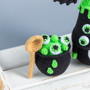 May include: A crocheted cauldron filled with green goo and eyeballs, a crocheted witch with a green hat and a crocheted wooden spoon.