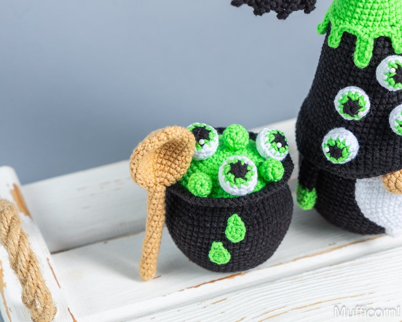 May include: A crocheted cauldron filled with green goo and eyeballs, a crocheted witch with a green hat and a crocheted wooden spoon.