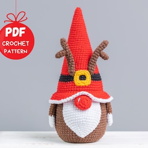 May include: A crochet reindeer gnome pattern in PDF format. The gnome is wearing a red hat with a white trim and a black belt with a yellow buckle. The gnome has a brown beard and a red nose.