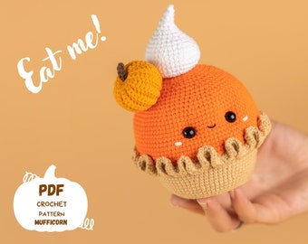 May include: A crocheted pumpkin pie amigurumi toy with a white whipped cream topping and a small pumpkin on top. The toy has a cute face with black eyes and a smile. The text "Eat me!" is written in white on a peach background. The text "PDF Crochet Pattern Mufficorn" is written in white on a white pumpkin shape.