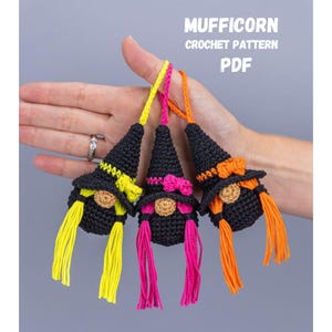 May include: Three crocheted gnome ornaments with black hats and colorful yarn hair. The gnomes have yellow, pink, and orange hair. The image includes the text "MUFFICORN CROCHET PATTERN PDF".