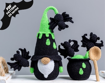 May include: A crocheted Halloween gnome with a green hat, black body, and white beard. The gnome is holding a black crocheted spider. There is a cauldron with a green liquid and a wooden spoon with a black crocheted spider on top.