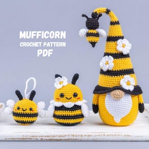 May include: A collection of handmade crochet items, including a bee-themed gnome and two bee ornaments. The gnome has a yellow and black striped hat with white flower accents. The text "MUFFICORN CROCHET PATTERN PDF" is visible.