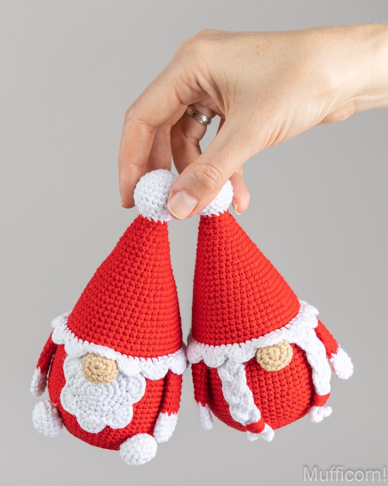 May include: Two crocheted gnome ornaments in red and white. The gnomes have white beards and white hats with red pom-poms.