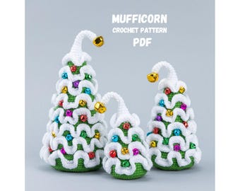 May include: Three crocheted Christmas trees in varying sizes. Each tree is green with white accents, colorful ornaments, and a gold bell at the top. The text "MUFFICORN CROCHET PATTERN PDF" is displayed in the background.