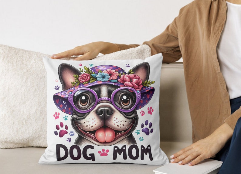 May include: White throw pillow with a cartoon image of a French bulldog wearing a purple and pink flower hat and sunglasses. The text "DOG MOM" is printed below the image.