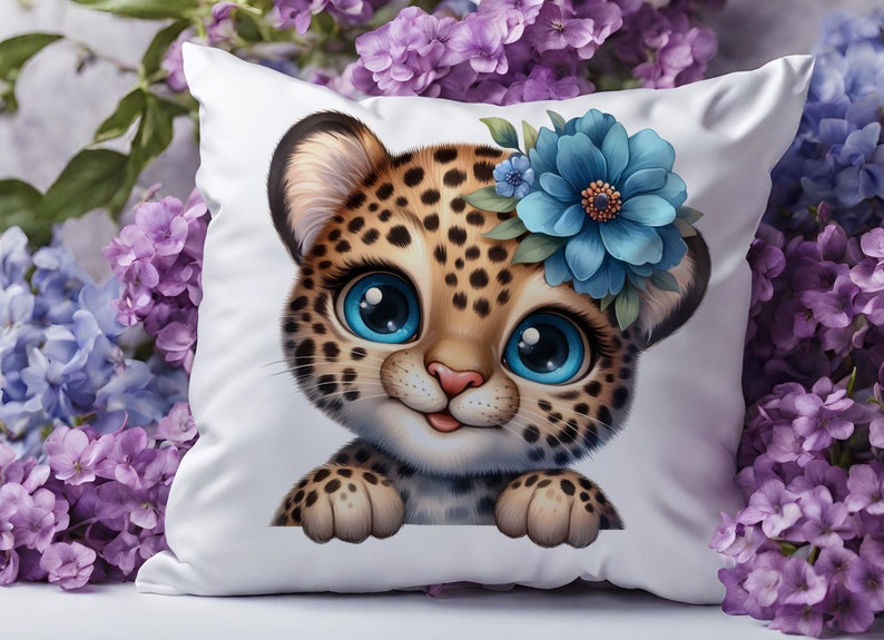 K&ouml;nnte beinhalten: Ein wei&szlig;es Kissen mit einem Cartoon-Bild eines Leopardenjungen mit blauen Augen und einer blauen Blumenkrone. Der Junge schaut &uuml;ber den Rand des Kissens.