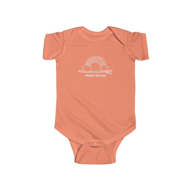 May include: A coral orange baby onesie with a white outline of a rainbow over a surfboard and the text "MAKE WAVES".