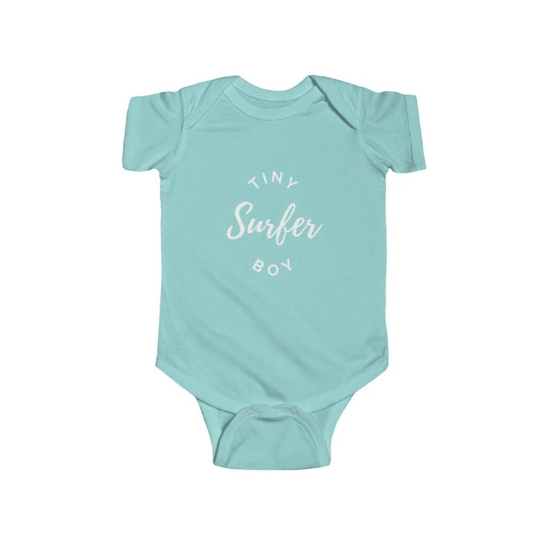 Puede incluir: Un body de beb&eacute; azul claro con texto blanco que dice "Tiny Surfer Boy".