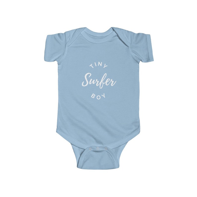 Puede incluir: Uniforme de beb&eacute; azul claro con texto blanco que dice "Tiny Surfer Boy".