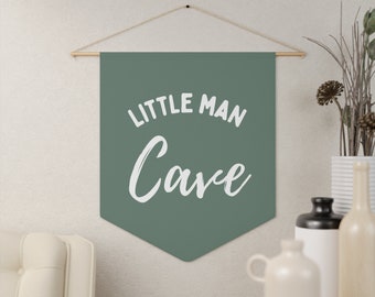 Peut inclure: Une bannière en feutre vert avec le texte "Little Man Cave" en lettres blanches.