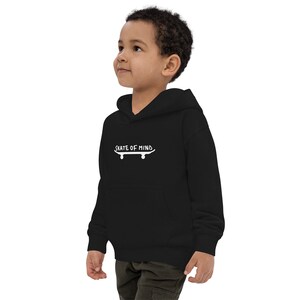 May include: Black hooded sweatshirt for kids with a white graphic of a skateboard and the text "Skate of Mind".