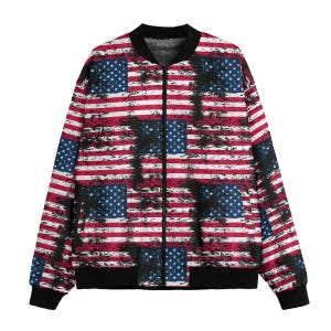 May include: Bomber jacket featuring a distressed American flag design. The jacket has a black collar, cuffs, and hem. The flag design includes red and white stripes with blue fields of stars.