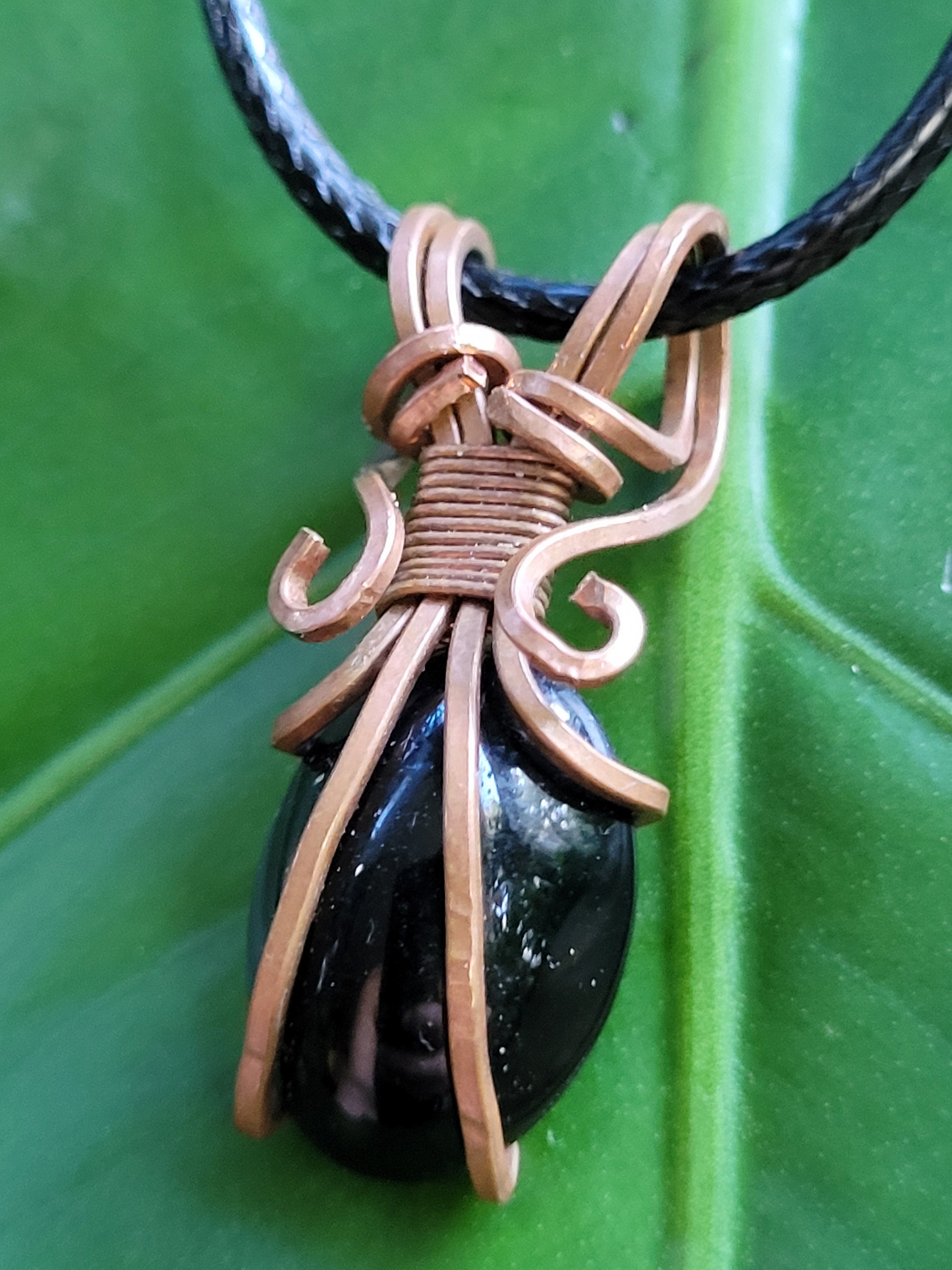 Black Obsidian wrapped in a uniquely designed copper pattern