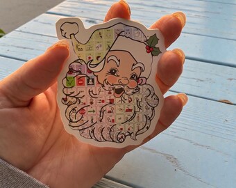 Può includere: Un adesivo raffigurante un Babbo Natale dei cartoni animati con barba e cappello bianchi e un disegno della tavola periodica sul viso e sulla barba. L'adesivo ha un bordo bianco e un rametto di agrifoglio sul cappello.