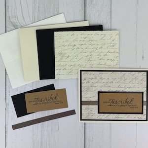 May include: A collection of stationery items, including cards, envelopes, and tags. The cards feature a script-like pattern and the word "Inscribed" with the text "you are on the palm of his hand..." in a brown rectangle.