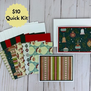 Puede incluir: Un juego de papelería con varias tarjetas de felicitación plegadas y sobres. Las tarjetas muestran varios patrones navideños, incluyendo caras de Papá Noel, rayas verticales en rojo y verde, y adornos navideños sobre un fondo verde oscuro.
