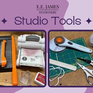 May include: A collection of craft supplies including a black paper trimmer with an orange handle, a white die-cutting machine, clear acrylic blocks, a red ink pad, a rotary cutter, a green cutting mat, scissors, and a metal heart die.