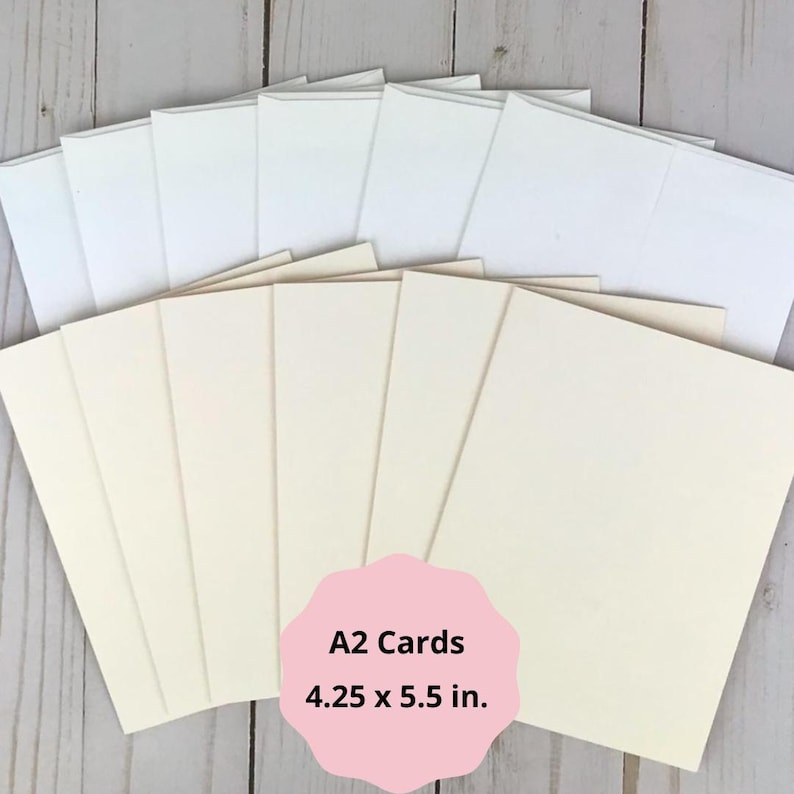 May include: A collection of A2 cards, measuring 4.25 x 5.5 inches, with matching envelopes. The cards are a soft cream color, and the envelopes are white. The image includes a pink label with the text "A2 Cards 4.25 x 5.5 in."