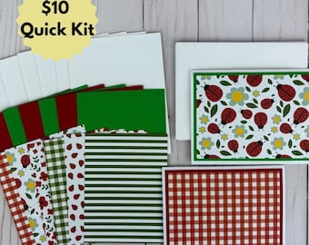May include: A stationery set featuring white envelopes and various cardstock sheets with patterns including red ladybugs on white, red and white gingham, green and white stripes, and floral designs. The text $10 Quick Kit is visible.