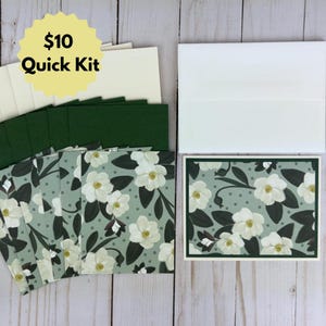 May include: A set of blank greeting cards with green envelopes and white floral patterned cards. The cards are arranged in a stack with a yellow starburst sticker that says "$10 Quick Kit".