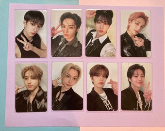 May include: A set of eight photo cards featuring different members of a boy band. Each card has a white border and features a close-up photo of a band member making a peace sign gesture. The background of each photo is blurred.