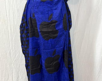 May include: A blue and black patterned caftan dress. The dress features a large apple design in black against a blue background. The sleeves are short and the neckline is square. The fabric appears to be lightweight.