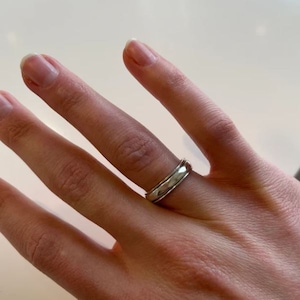 May include: A silver band ring with a hammered finish.