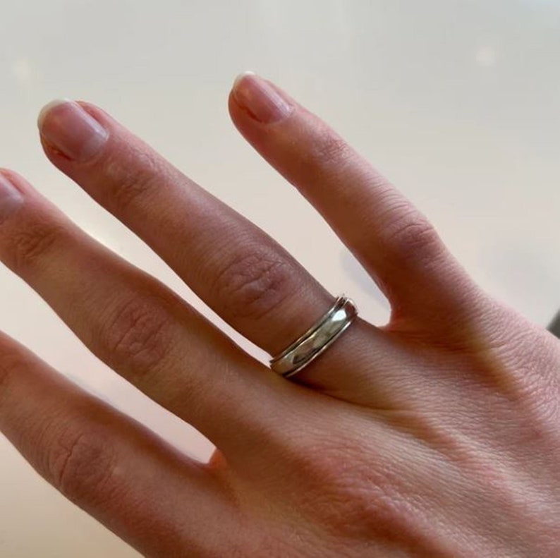 May include: A silver band ring with a hammered finish.
