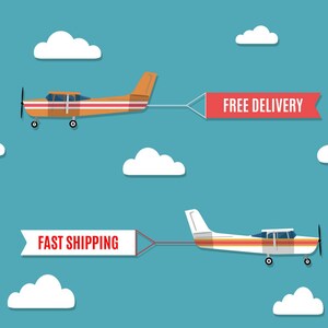 May include: Two small airplanes flying in a blue sky with white clouds. One plane is orange and pulls a banner that reads "FREE DELIVERY." The other plane is white and pulls a banner that reads "FAST SHIPPING."