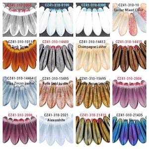 May include: A collection of 12 different colored glass beads, each with a unique luster finish. The beads are arranged in four rows of three, with each row representing a different color family. The beads are all in the shape of a teardrop, with a pointed tip and a rounded base. The beads are all approximately the same size, and they are all strung on a wire.