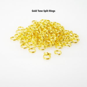 May include: A large pile of gold-tone split rings. The rings are small and round, and they are perfect for making jewelry or other crafts.