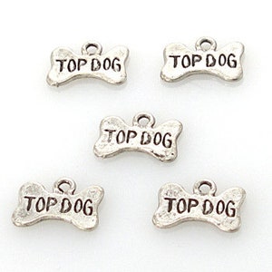 May include: Five silver-tone metal charms shaped like dog bones with the words "Top Dog" engraved on each charm.
