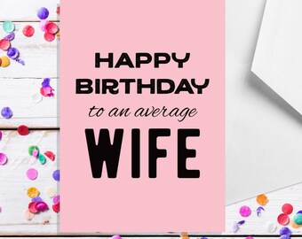 以下が含まれることがあります： ピンクの誕生日カードに、黒い文字で「Happy Birthday to an average Wife」と書かれています。