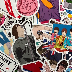 May include: A collection of colourful stickers featuring various designs, including a heart-shaped sticker with the text "Stolen Sweet Hearts", a sticker of a person singing into a microphone, and a sticker of a band with the text "Superwooni".