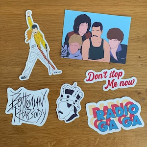 May include: A set of five stickers featuring a Queen-themed design. The stickers include a black and white illustration of Freddie Mercury, a sticker with the text "Don't stop me now", a sticker with the text "Radio Ga Ga", a sticker with the text "Bohemian Rhapsody", and a sticker with a cartoon illustration of Freddie Mercury wearing a crown.