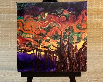 May include: An abstract painting of a tree with a vibrant sunset. The artwork features a dark purple and orange sky with swirling patterns. The tree has green leaves and brown trunk. The painting is displayed on a small black easel.