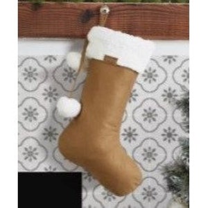 May include: A brown suede Christmas stocking with a white faux fur cuff and white pom-poms hanging from the top.
