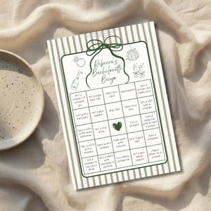Op de afbeelding: Een gedrukte bingokaart voor een vrijgezellenfeest met een groen-witte gestreepte rand. De kaart bevat de tekst "Rebecca's Bachelorette Bingo" en bevat verschillende leuke activiteitsprompts.