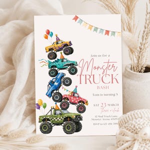 May include: A birthday invitation card featuring a stack of five colorful monster trucks wearing party hats, decorated with balloons and bunting. The text reads: Join us for a Monster TRUCK BASH, Tom is turning 5, SAT 23 MARCH, Three o'clock, 12 Mud Truck Lane, Monster Arena, 676554, RSVP to 123-456-7890.