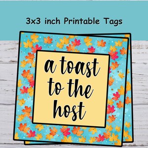 Op de afbeelding: Bedrukbare labels van 7,6 x 7,6 cm met een turquoise achtergrond en een patroon van oranje, gele en rode herfstbladeren. De labels hebben een gele kern met de tekst "a toast to the host" in zwart.