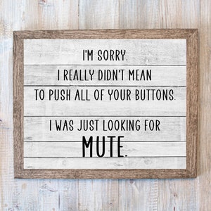 May include: A framed sign with a white wood background and black text that reads "I'M SORRY. I REALLY DIDN'T MEAN TO PUSH ALL OF YOUR BUTTONS. I WAS JUST LOOKING FOR MUTE."