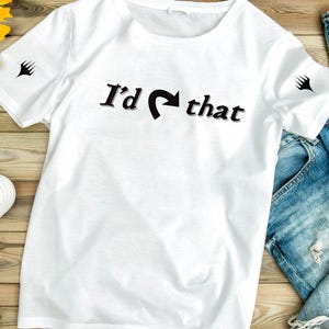 May include: White t-shirt with a black graphic that says "I'd that" with a curved arrow pointing to the right.
