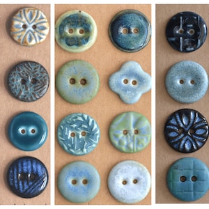 Può includere: Una collezione di ventiquattro bottoni in ceramica disposti in una griglia, caratterizzati da varie tonalità di blu, verde e crema. I bottoni presentano texture diverse, tra cui superfici lisce, smaltate, in rilievo e decorate, ciascuno con due o quattro fori.