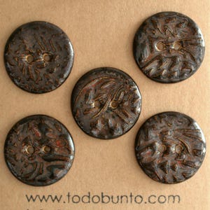 May include: Five circular ceramic buttons with a dark brown, glossy, textured glaze and two central holes. Each button features an irregular, raised pattern across the surface. The text www.todobunto.com is printed at the bottom of the image.