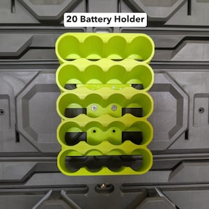 K&ouml;nnte beinhalten: Ein limettengr&uuml;ner 20-Batterie-Halter. Der Halter besteht aus Kunststoff und hat ein gitterartiges Design mit zwanzig kreisf&ouml;rmigen Schlitzen. Der Text "20 Battery Holder" wird in wei&szlig;er Schrift oben im Bild angezeigt.