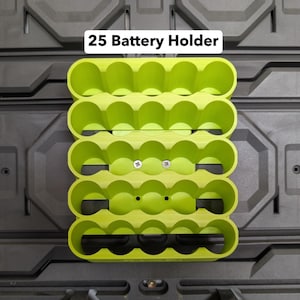 K&ouml;nnte beinhalten: Ein limettengr&uuml;ner 25-Batteriehalter mit f&uuml;nf Reihen zu je f&uuml;nf kreisf&ouml;rmigen Schlitzen. Der Halter ist auf einer dunkelgrauen, strukturierten Oberfl&auml;che montiert. Der Text "25 Battery Holder" wird oben in Wei&szlig; angezeigt.